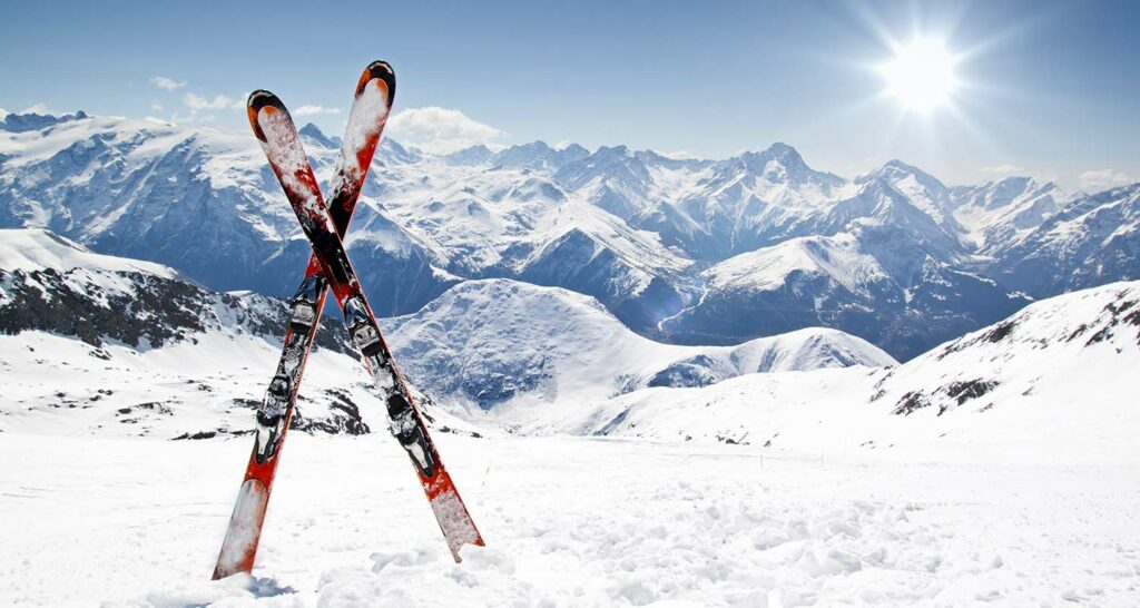 Où partir en février : une paire de skis plantée dans la neige