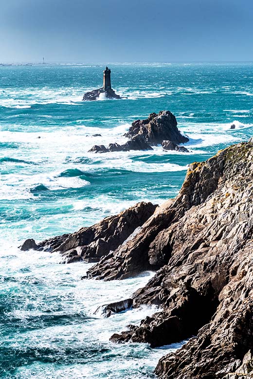 Que faire en Bretagne : Vue sur un phare au bord de la côte.