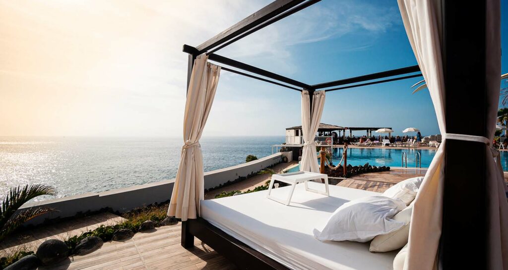 Voyage de luxe : Terrasse d'un hôtel de luxe avec piscine et vue sur la mer.