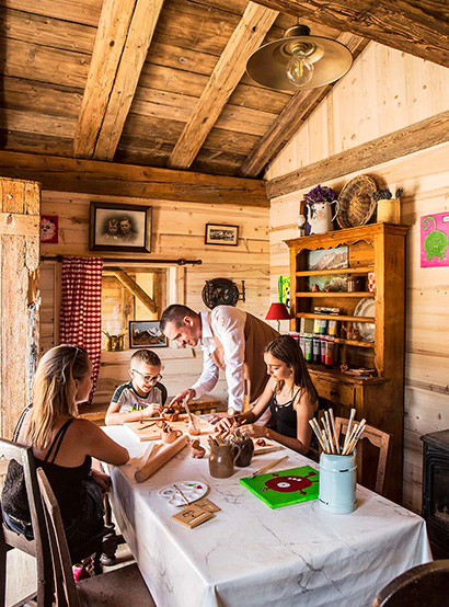 Vacances en famille : deux enfants et leur maman réalisant une activité créative