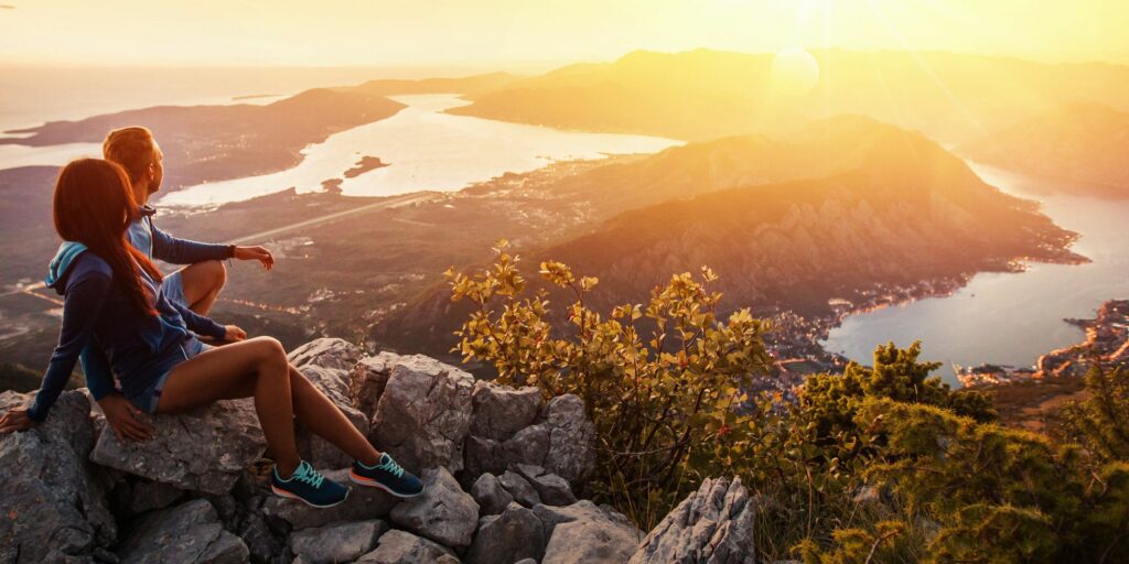 Écotourisme : un couple admirant un paysage naturel au lever du soleil