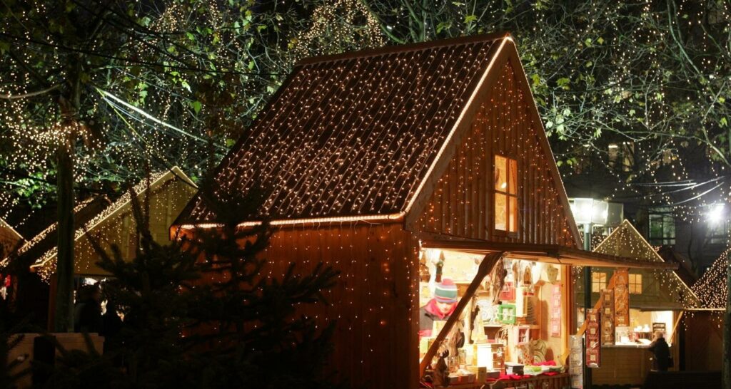 Vacances de Noël : allée de marché de noël avec chalet en bois