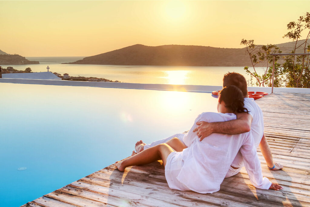 week-end en amoureux : un couple au bord de la piscine d'un hotel au coucher du soleil