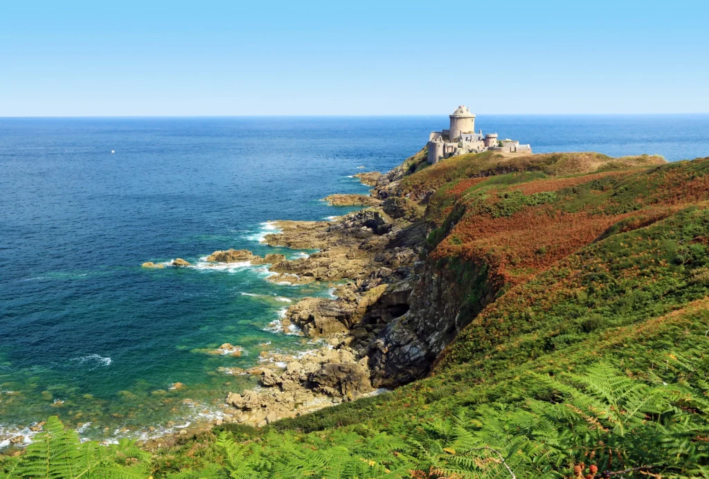 Paysage typique de Bretagne avec côtes escarpées et paysages verdoyants.