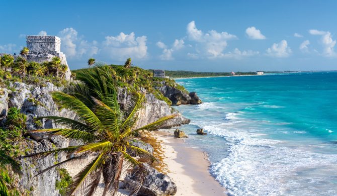 Ruins of Tulum, Mexico and a palm tree overlooking the Caribbean Sea in the Riviera Maya