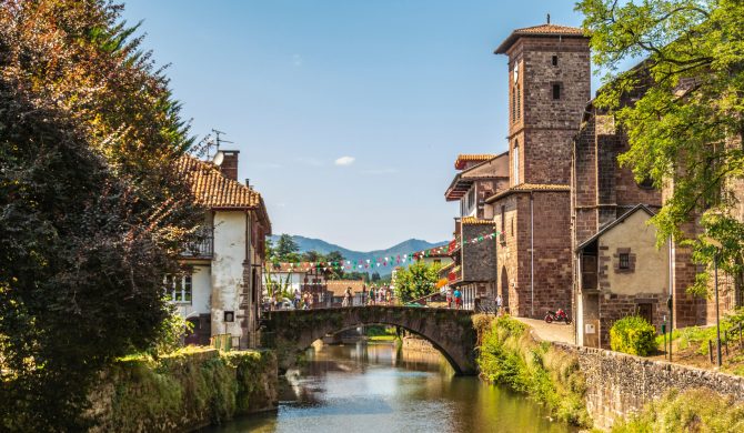 View of the river Nive on its way through the village of Saint Jean Pied de Port and in the background the Pyrenees. France.