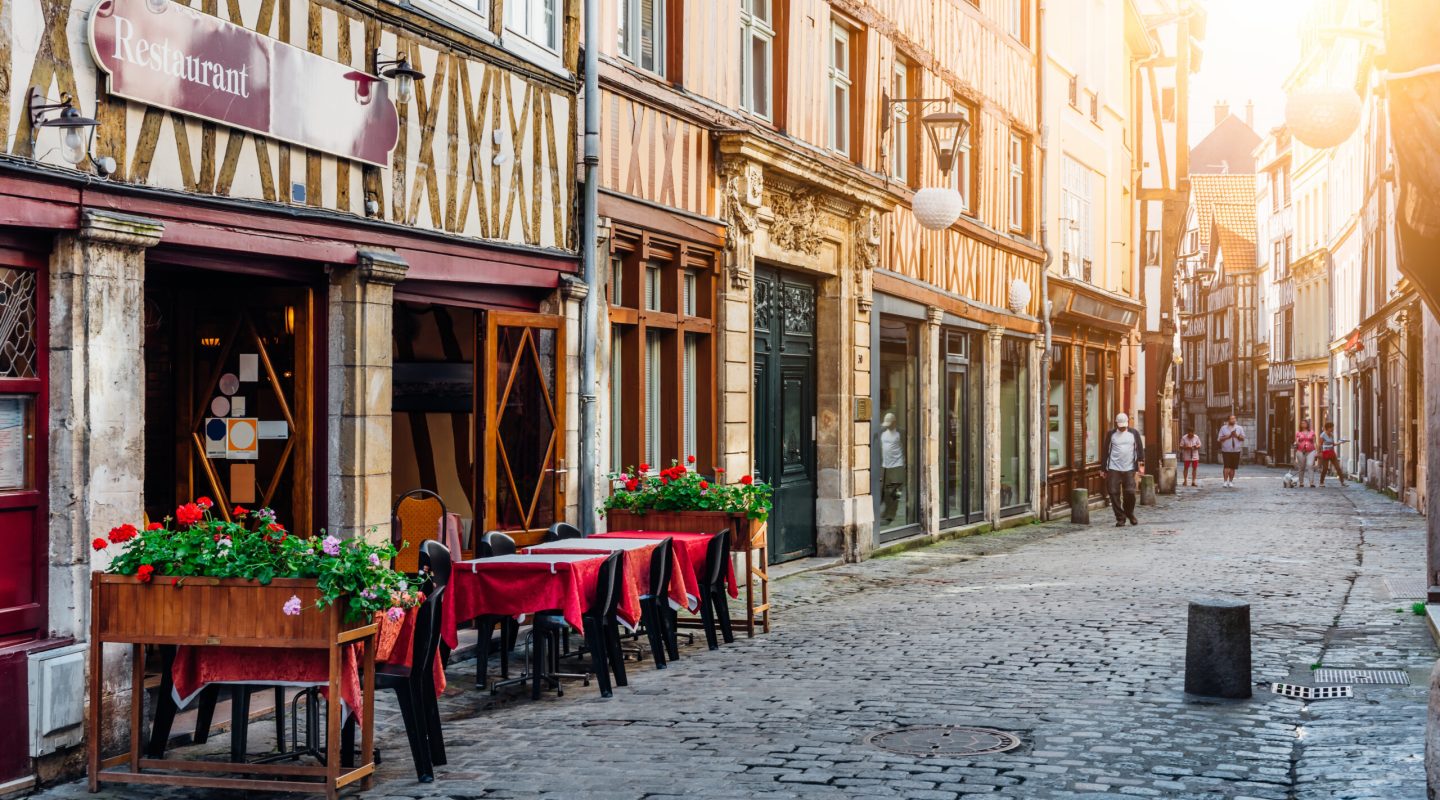 Cozy street with timber framing houses and tables of restaurant in Rouen, Normandy, France