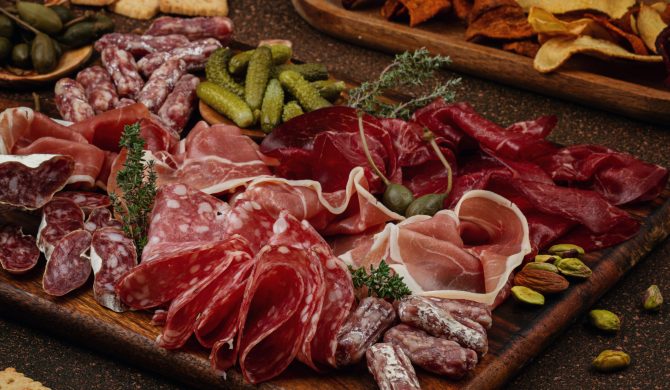 Appetizers table with differents antipasti, charcuterie, snacks and wine. Sausage, ham, tapas, olives, cheese and crackers for buffet party. Top view, flat lay