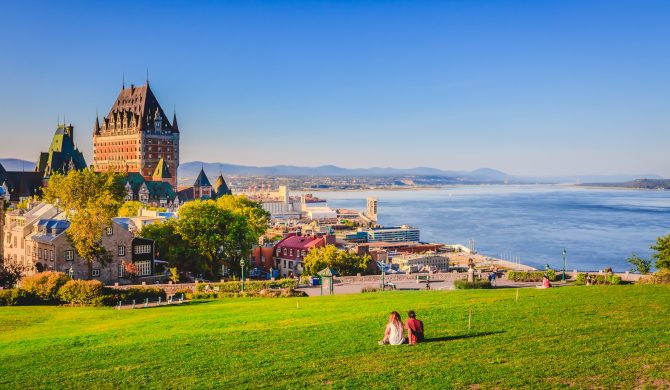 Cityscape view of Old Quebec City with buildings, green grass ag