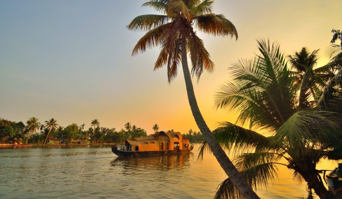 A boat sailing on Kerala backwaters during sunset.