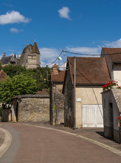 Village of La Rochepot and castle La Rochpot with street and houses with flowers, France.