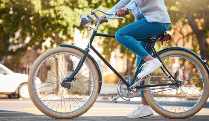 Adventure, street travel and bike break outdoor in urban city in summer. Woman with vintage bicycle in a road for transport. Sustainability person traveling with health mindset or healthy energy.