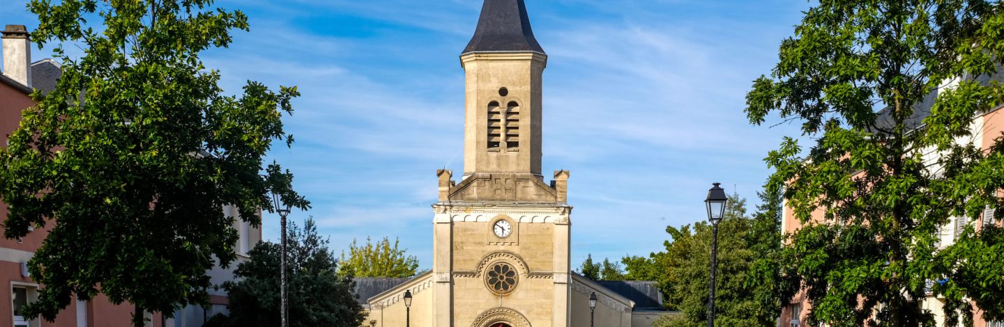 Axial view of St-Jacques Church in Montgeron, France, seen the mqin street and taken on a sunny summer day.