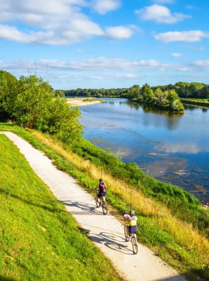 Cyclistes parcourant la Loire à Vélo entre vignobles et châteaux lors d’un séjour en Pays de la Loire.