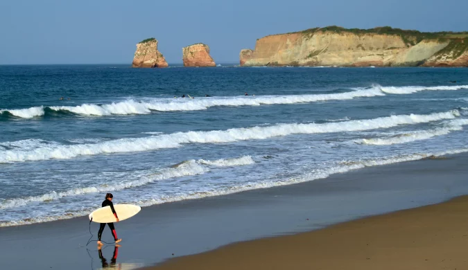 Surfeur sur la plage d'Hendaye lors d'un week-end de novembre idéal pour les amateurs de vagues.