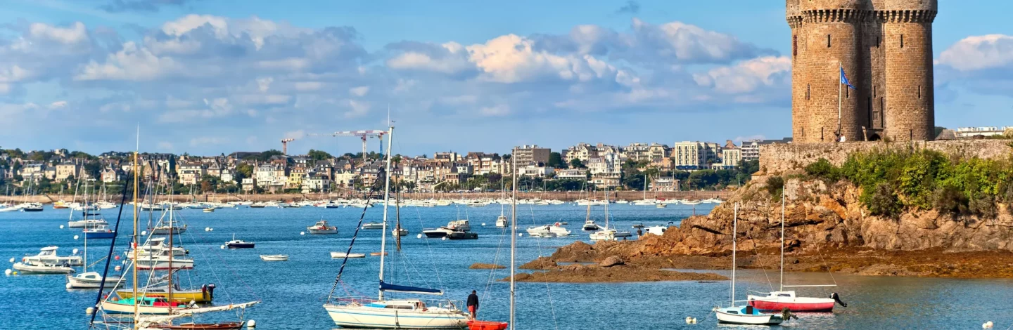 Vue panoramique de Saint-Malo depuis la mer, avec ses remparts et la vieille ville.