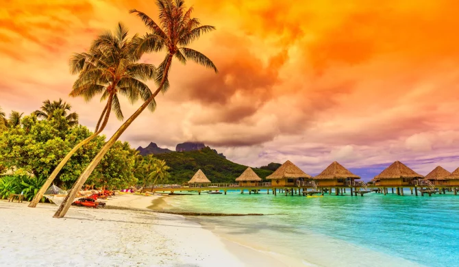 Magnifique coucher de soleil sur l'océan à Bora Bora avec des couleurs orangées et des montagnes en arrière-plan