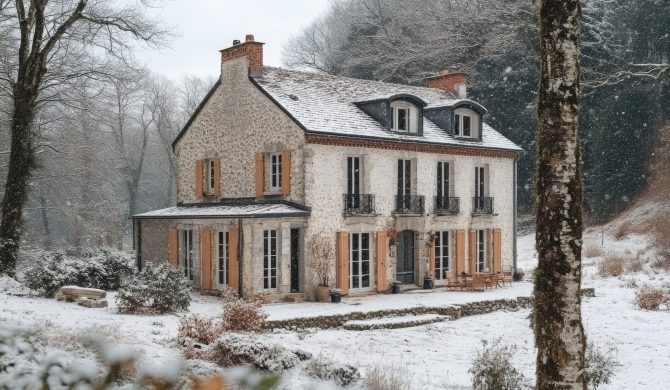 Stone cottage glows with warm light on a snowy evening, promising warmth and comfort inside