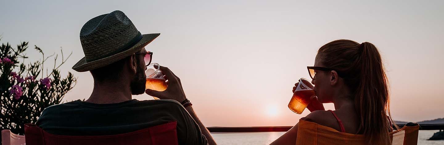 Un couple qui boit un verre devant le coucher du soleil