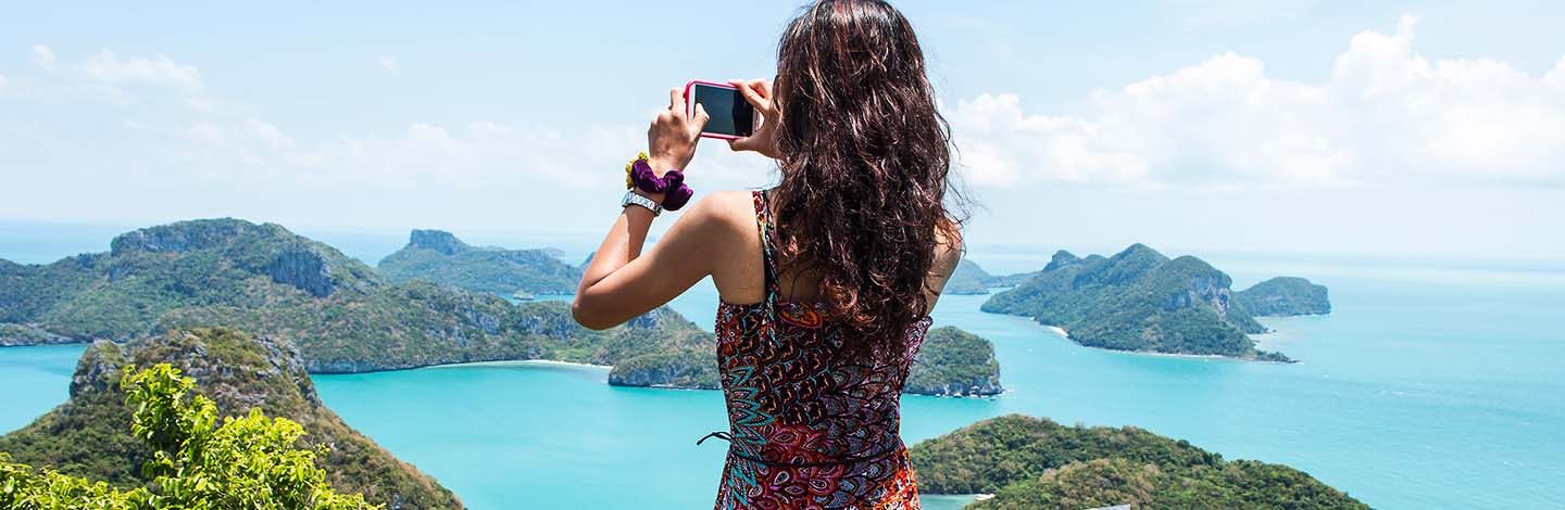 Accessoire voyage : Une femme prend en photo le paysage avec son smartphone.