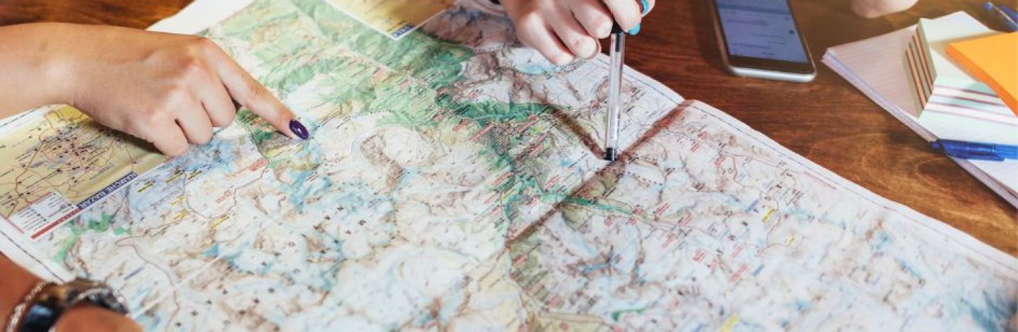 voyageurs entrain d'organiser ses vacances avec un carte du monde